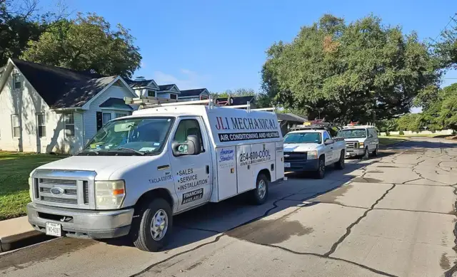 JLI Mechanical service vehicles outside a customer's home in a pretty residential area.